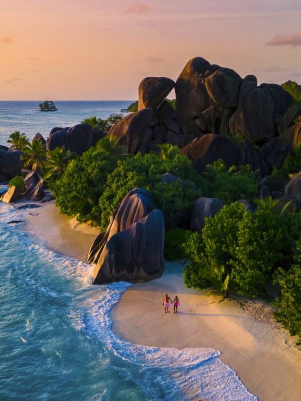 Anse Source d'Argent, La Digue Seychelles, a young couple of Caucasian men and Asian women on a tropical beach during a luxury vacation in Anse Source d'Argent, La Digue Seychelles